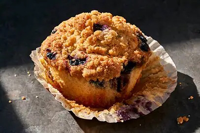 Picture of a blueberry muffin in its wrapper.
